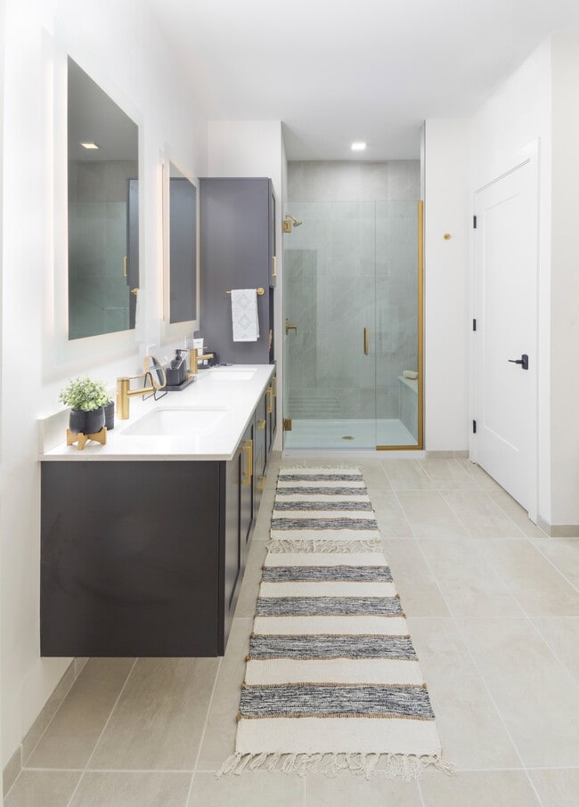 Spa-inspired bathrooms with frameless glass showers and rainfall shower heads, dual floating vanities, backlit mirrors*