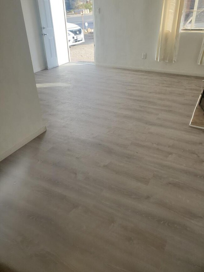 Brand new laminate plank flooring in living area & bedroom - 6432 Smoketree Ave