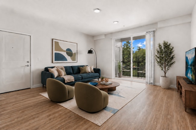 Staged living room illustrating a comfortable furniture layout with direct access to the private balcony.