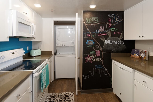 Standard Apartment Kitchen with Chalkboard Accent Wall and Washer Dryer