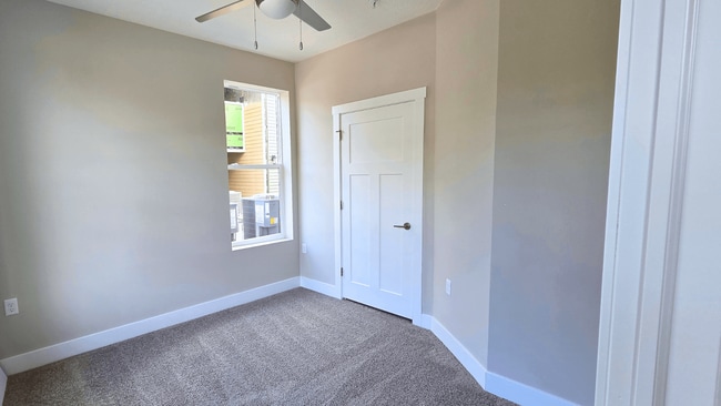A carpeted bedroom with ceiling fan of an available apartment home at Greenwood Commons Apartments in Delaware, OH. - Greenwood Commons Apartments