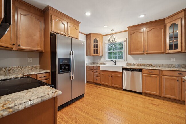 Kitchen with farmhouse sink, ss appliances and granite counters - 1818 Woodland Dr Casa