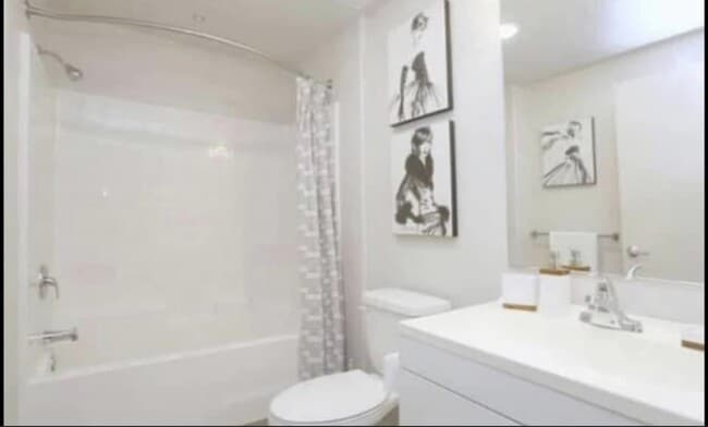 Baño con accesorios y armarios blancos en City Plaza Apartments en Escondido, California. - City Plaza Apartments