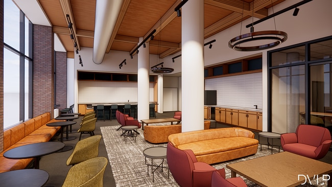 Moderno salón común con elegantes asientos de cuero, elegantes sillas decorativas y grandes ventanales que ofrecen luz natural. - Bogen | Urban Chic Lofts