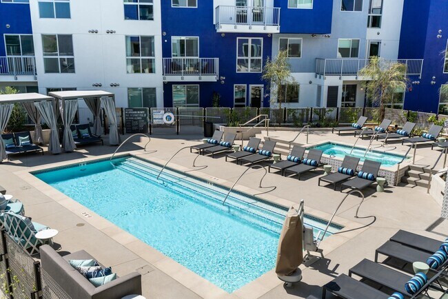 Resort-style pool deck with private cabanas, sun loungers, and spa access, creating a vibrant setting for relaxation and outdoor gathering.