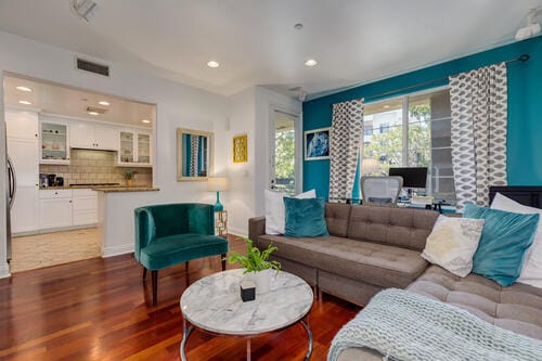 Sala de estar con grandes ventanales y chimenea, y acceso al patio en la planta baja. - 5831 Seawalk Dr