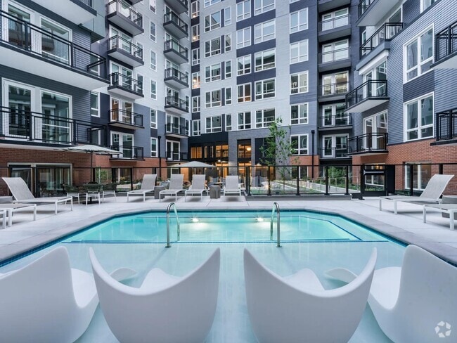 Soak, sun, and unwind in our resort-style courtyard pool, complete with in-water loungers, private seating, and a peaceful city backdrop. - Modera H Street Rental