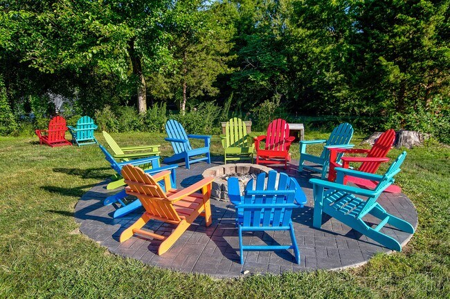 Outdoor seating area with colorful Adirondack chairs surrounding a cozy fire pit.