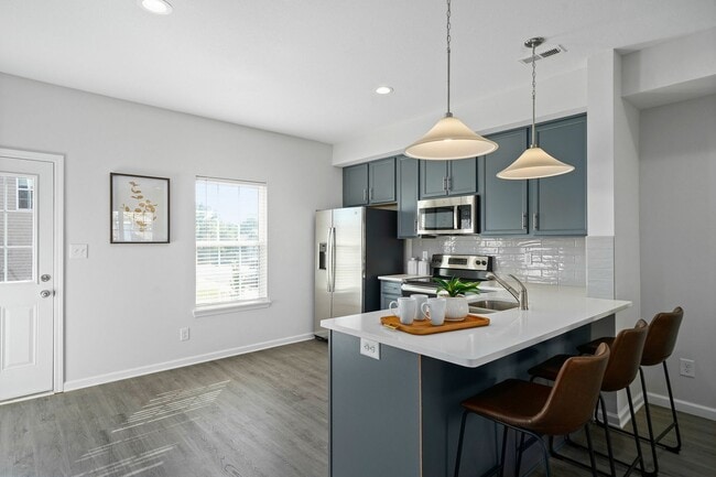 Kitchen area with breakfast bar, modern cabinetry, and stainless steel appliances
