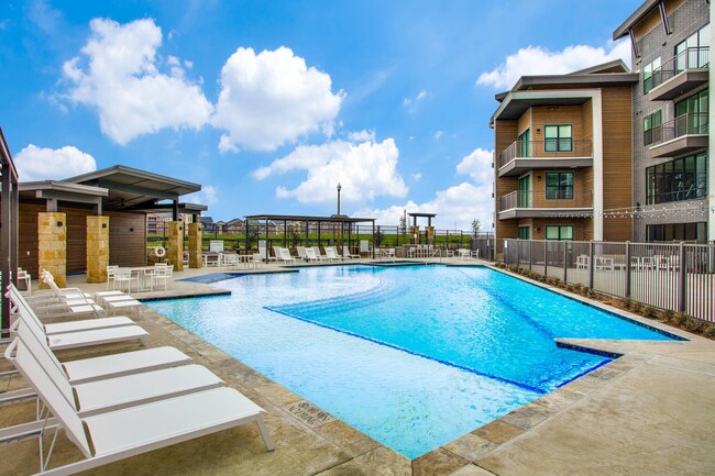 Piscina con estilo de centro turístico en comunidad para personas mayores en Denton - The Vista at Rayzor Ranch Apartamentos