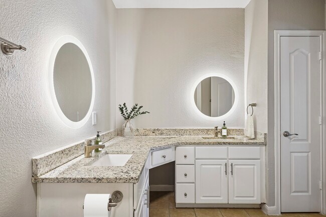 Bath with white cabinetry, speckled granite countertops, and hard surface flooring