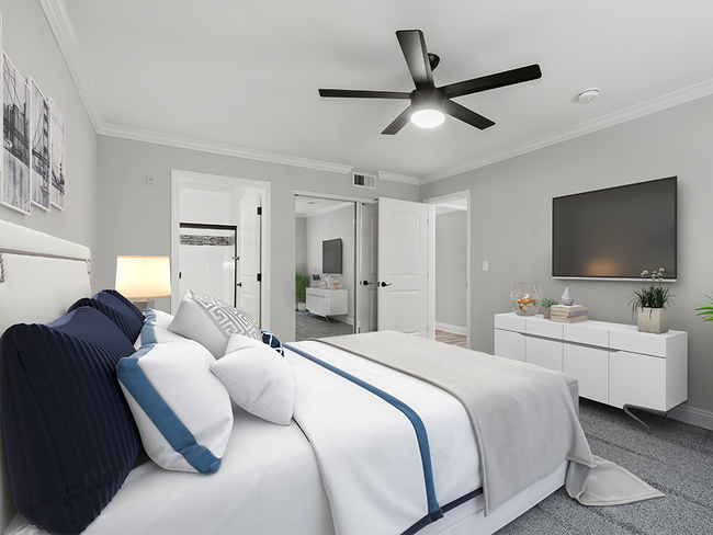 Habitación alfombrada con ventilador de techo y baño privado.