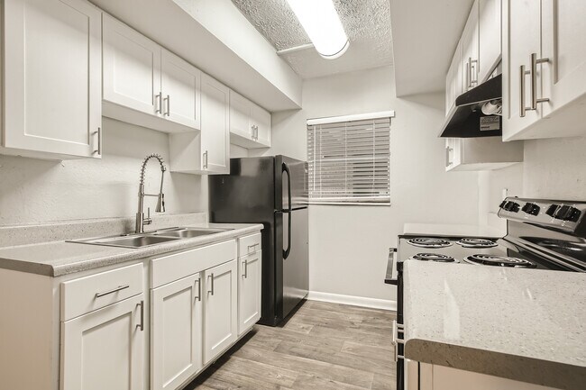 Bright and modern kitchen featuring sleek white cabinetry, elegant countertops, and stainless steel fixtures creating a chic culinary space.