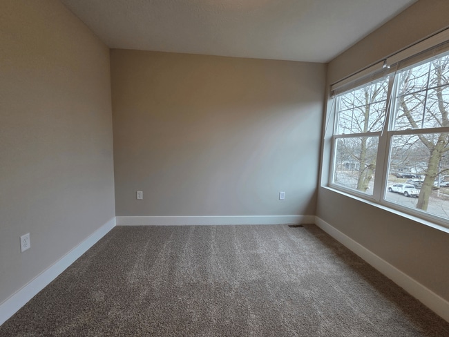 Townhome secondary bedroom with window view. - Flats at Sugar Run