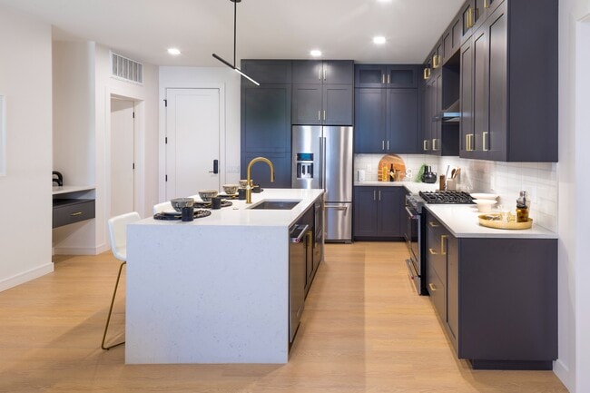 Gourmet kitchens with custom cabinetry, brushed brass hardware and under-cabinet lighting