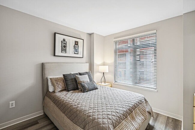 Espacio suficiente en el suelo para una cómoda y un sillón de lectura junto a la cama.