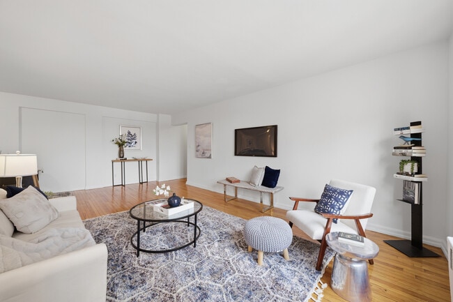 Bright living room with hardwood floors and seamless access to a balcony showcasing the Hudson River - 555 Broadway Unit 4F
