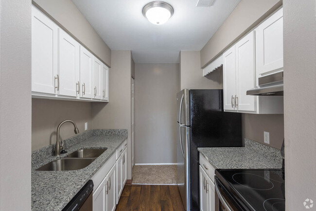 Galley-Style Kitchen With Stainless Appliances - Brighton Glens Apartments