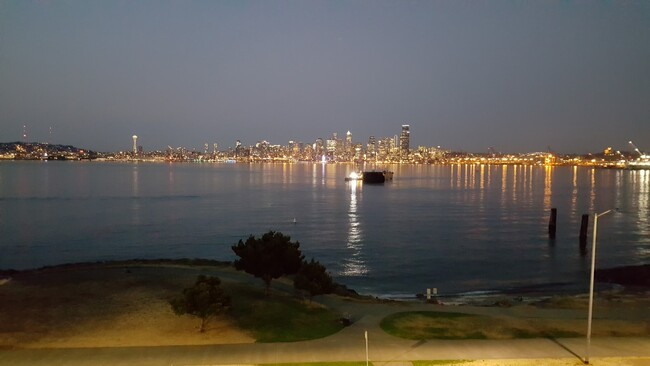 Enjoy the view day AND night! Twilight view of Elliott Bay right from living room. - 1737 Harbor Ave SW Apartment Unit S-405 Unit S-405