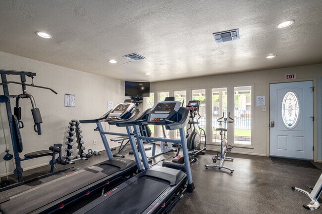 Modern fitness center at Madeira Apartments with cardio and strength training equipment. - Madeira Apartments