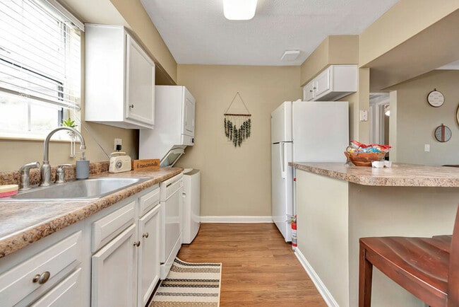 Spacious Kitchen with Ample Counter Space and Stacked Laundry Machines at The Commons Student Apartments in Oxford, OH