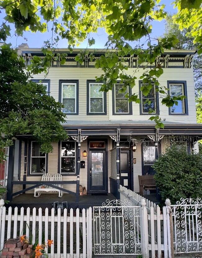 Charming front view of home featuring a relaxing porch with rocking chair. - 424 1/2 S Pine St Casa