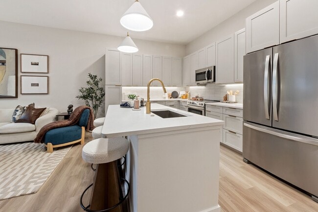 Upscale living starts in the kitchen: premium quartz countertops, stainless steel appliances, and designer lighting creates a space that is both stylish and functional