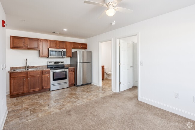 Carpeted living room towards kitchen.