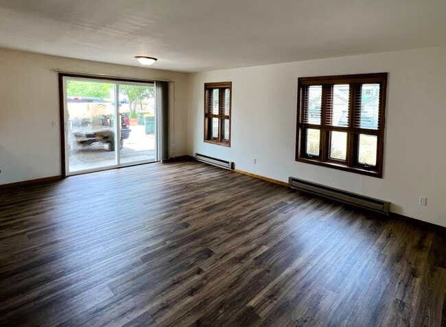 open-concept living and dining area with large windows bringing in plenty of natural light