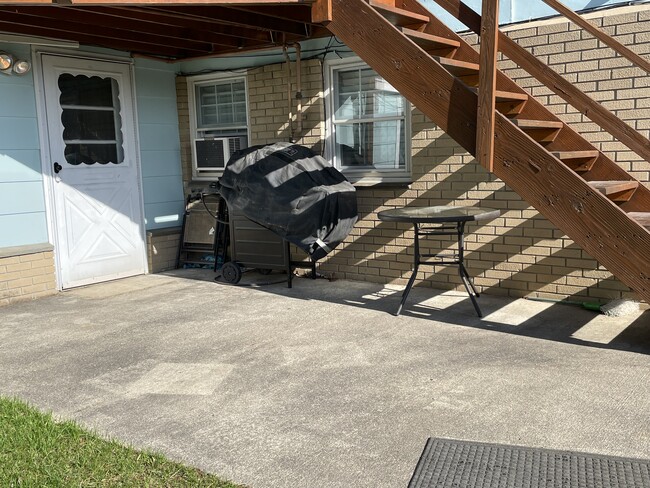 Área de patio al aire libre con parrilla a gas y puerta a la lavandería compartida en el lugar. - 6030 NY-23 Unidad SS103