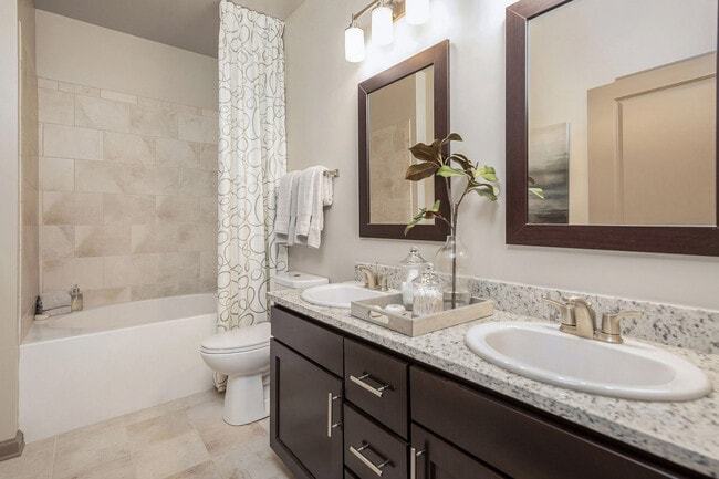 Modern bathroom with dual vanities, granite countertops, and updated finishes—comfortable, stylish apartment living in Charlotte.