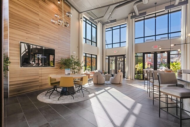 Sunlit clubroom with seating and courtyard views for a warm welcome home - Stadium Walk By Windsor