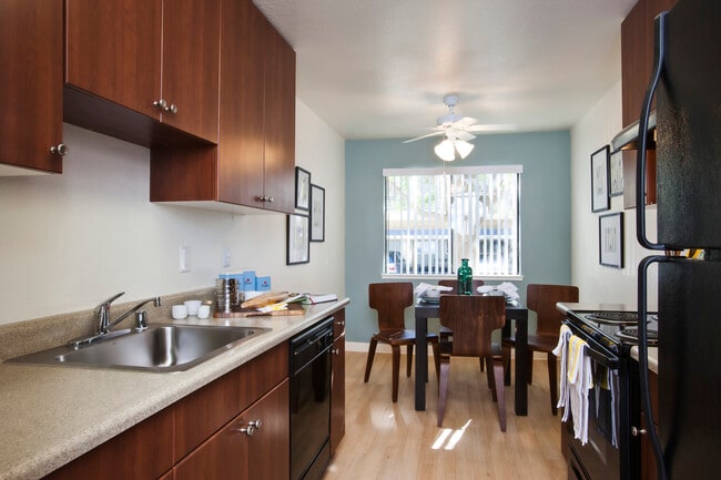 Classic Package I kitchen with oak cabinetry, beige laminate countertops, black appliances, and hard surface flooring