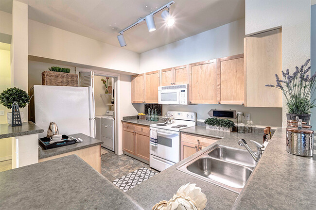 Open kitchens with energy efficient appliances, including dishwasher and mounted microwave - The Lodge at Redmond Ridge Apartments