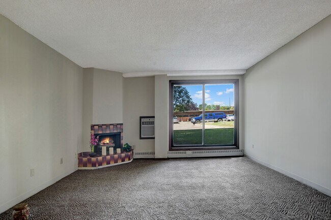 A living room with fireplace and large sliding glass doors - Edgemont Heights