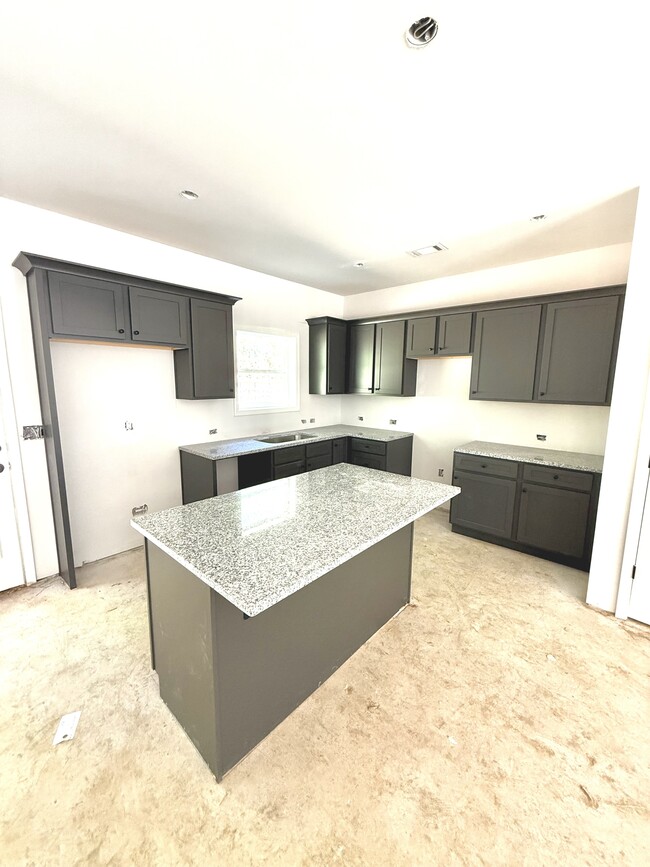 Large kitchen with granite countertops and island. Plenty of cabinet space.