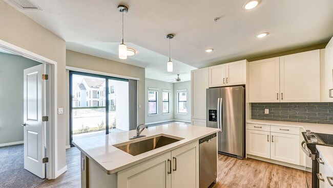 Imperial Crossing Luxury Apartment Homes unit showing a modern kitchen with stainless steel appliances and white cabinets. - Imperial Crossing Luxury Apartment Homes