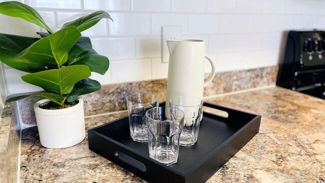 Experience kitchen design at its best with subway tile backsplash and granite-style countertops, inspiring your culinary creativity. - Indigo Isles