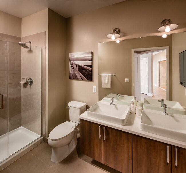 Signature Collection Bathroom with oak cabinetry light grey quartz countertops, white tile backsplash, and tile flooring - Avalon Princeton