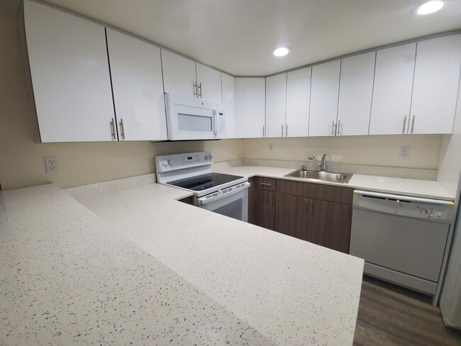 Kitchen with Granite Countertops with Modern, White Plywood Cabinetry with Self-Closing Hinges* - Country Club Towers