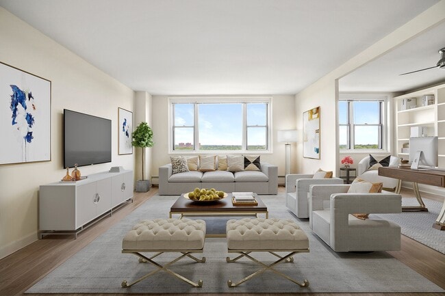 Bright and modern living room featuring plush seating, stylish decor, a large window with scenic views, and a beautiful workspace at Parkside Place, apartments in Cambridge, MA