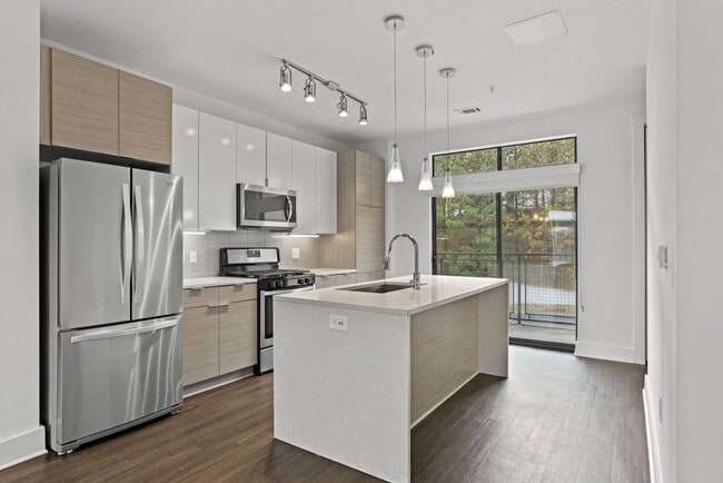 Stainless steel appliances, gas range, pendant lighting, and an island with space for bar stools - Windsor Encore Apartments