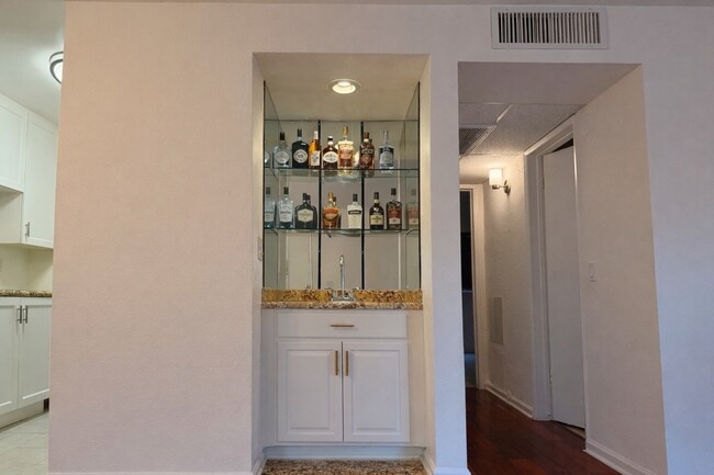 Built-in wet bar with mirrored glass shelving and granite counter — a WeHo entertainer's dream - 970 Palm Avenue Unit 107