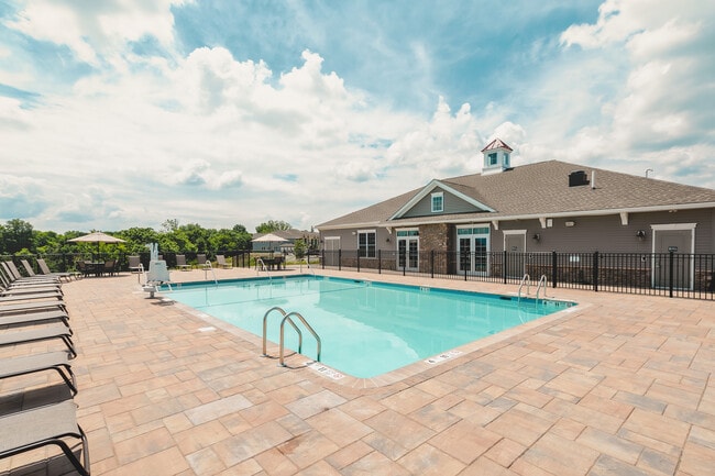 Experience relaxation by the heated outdoor pool, perfect for basking in the sun or enjoying a refreshing swim. - Meadow Ridge Luxury Apartments
