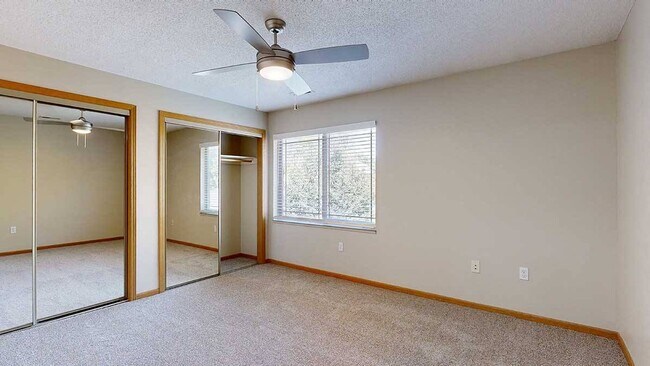 The Findad bedroom features large windows, mirrored closets, and a ceiling fan for added comfort.