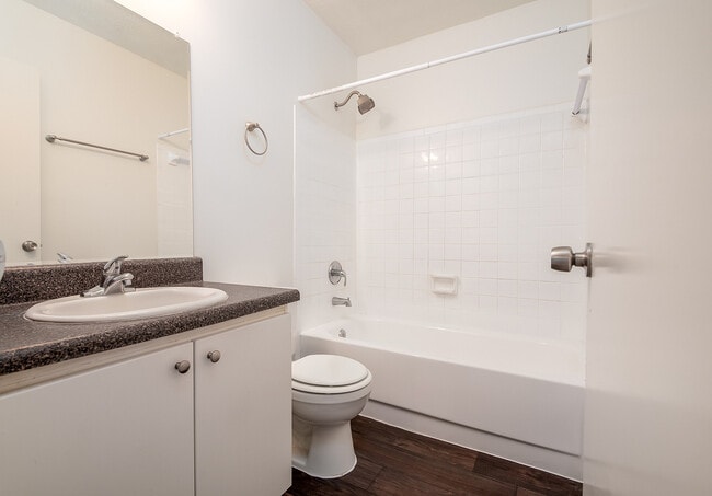 Modern bathroom with sleek white tiles, elegant vanity, and a clean bathtub, perfect for relaxation and rejuvenation.