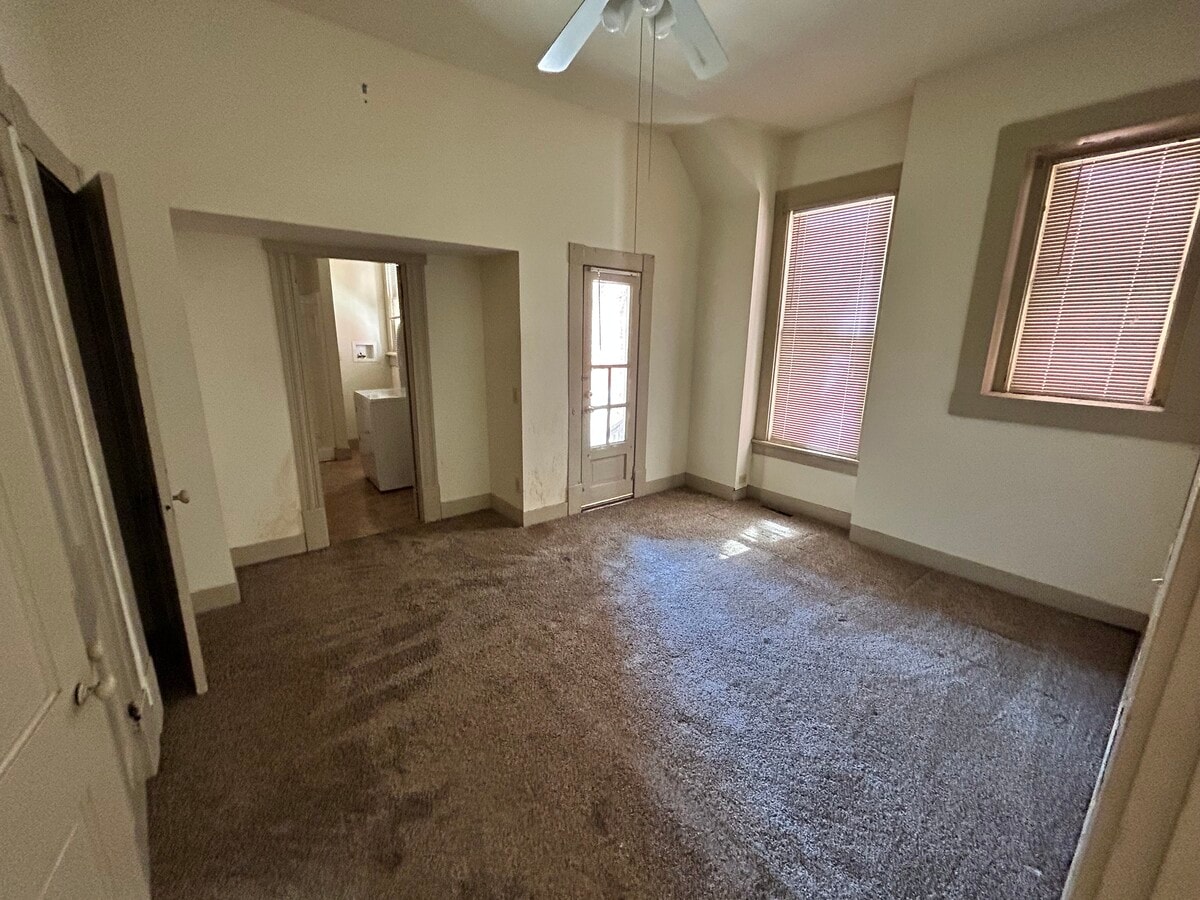Dormitorio (con la pintura antigua) con baño completo al que se accede por la puerta de la izquierda. - 83 W 2nd Ave Unidad 102