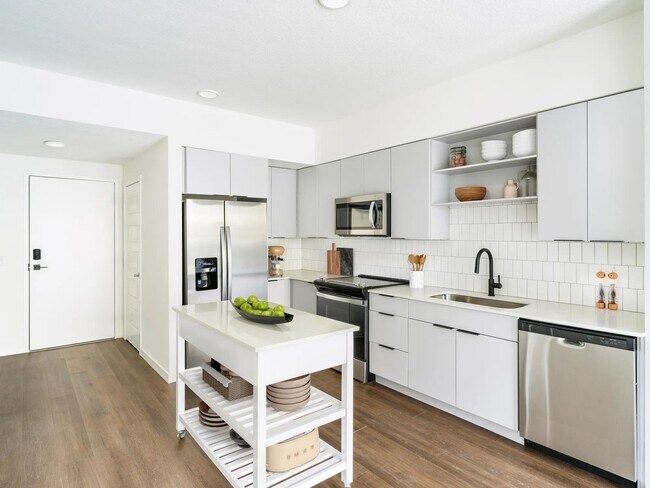 A light-cabinet kitchen with a movable island offers flexible, effortless living throughout your Modera Encore Tampa home. - Modera Encore
