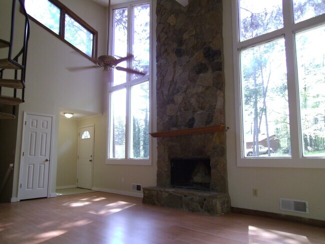 Living room with vaulted ceiling and stacked stone fireplace