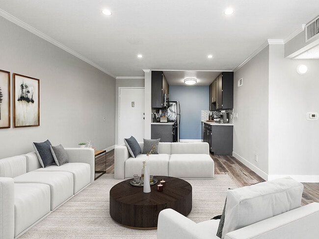 Hardwood floored living room with view of kitchen.
